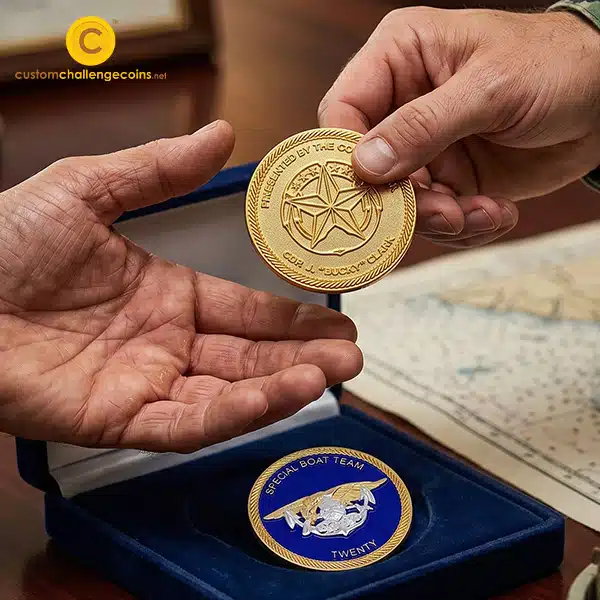 Two sailors exchanging a Navy challenge coin beside a Special Boat Team Twenty coin